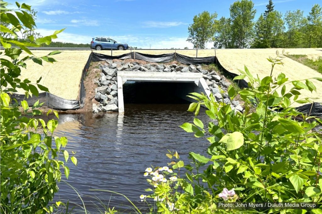A culvert with a road over the top and water below